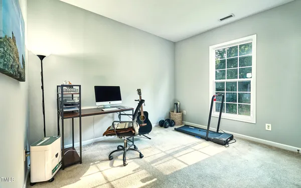 a view of a workspace with furniture and a window