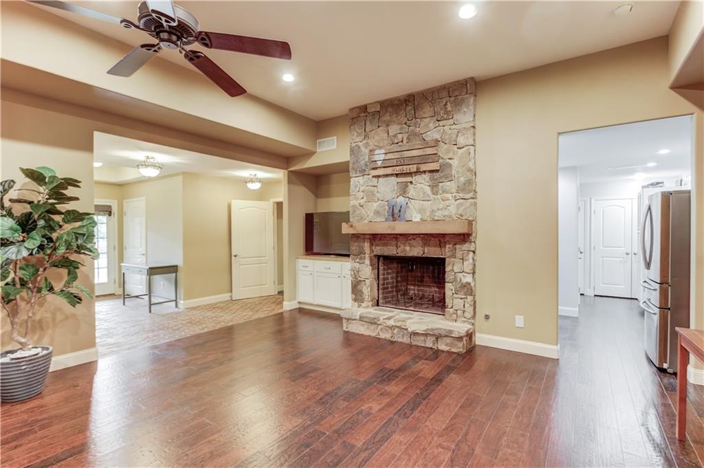 5667 Britt Whitmire Road Gainesville, GA 30506 - Photo 43 of 67 a view of a livingroom with a fireplace wooden floor and a ceiling fan