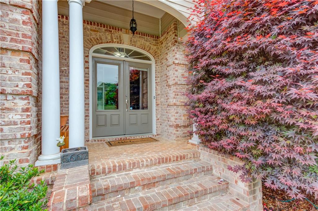 5667 Britt Whitmire Road Gainesville, GA 30506 - Photo 6 of 67 a view of a brick house with many windows and a tree
