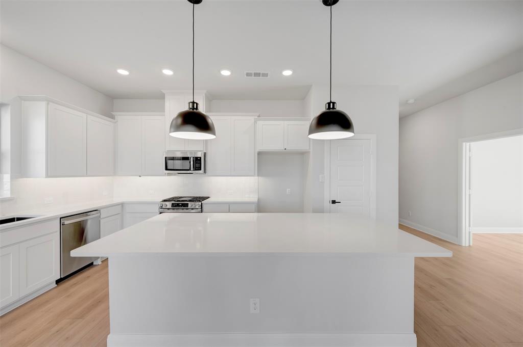 4022 Yellowstone Road Royse City, TX 75189 - Photo 6 of 20 a kitchen with stainless steel appliances kitchen island a stove a sink a center island and a cabinets