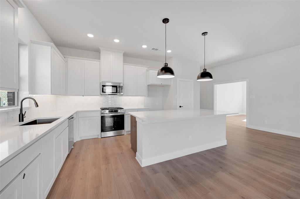 4022 Yellowstone Road Royse City, TX 75189 - Photo 9 of 20 a kitchen with stainless steel appliances granite countertop a sink a stove and a wooden floors
