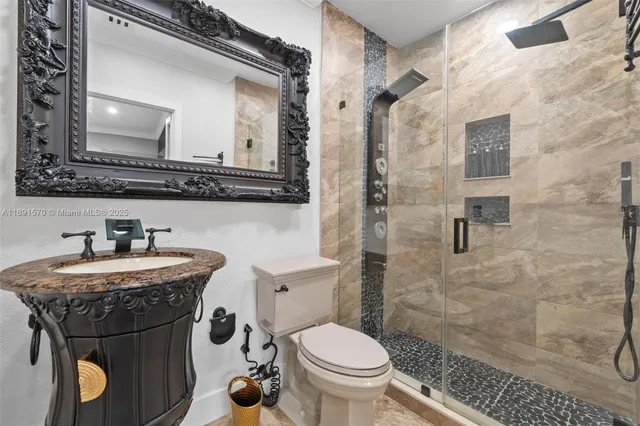 a bathroom with a granite countertop toilet sink and mirror