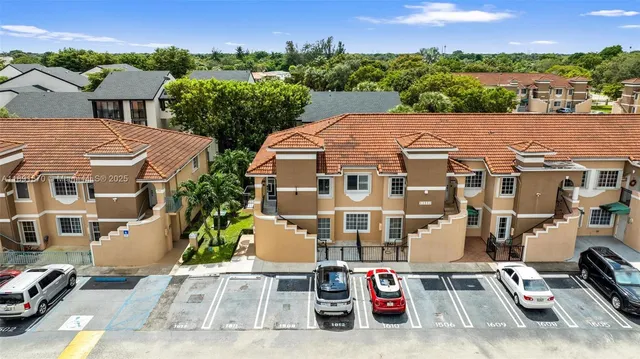 an aerial view of a house with a garden and a cars parked in front of it
