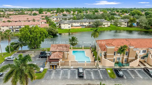 an aerial view of residential houses with outdoor space and lake view