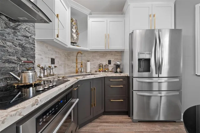 a kitchen with stainless steel appliances a refrigerator sink and cabinets