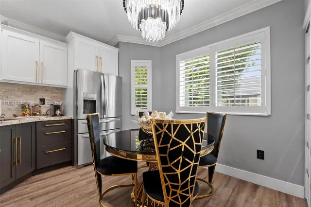 a kitchen with stainless steel appliances a refrigerator a stove a sink and dishwasher with wooden floor