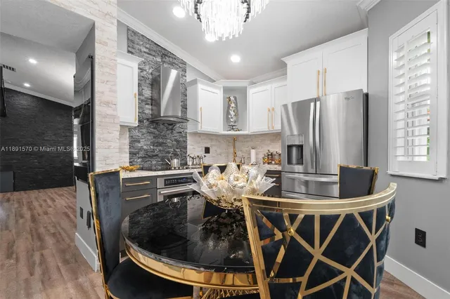 a kitchen with sink a refrigerator and chairs