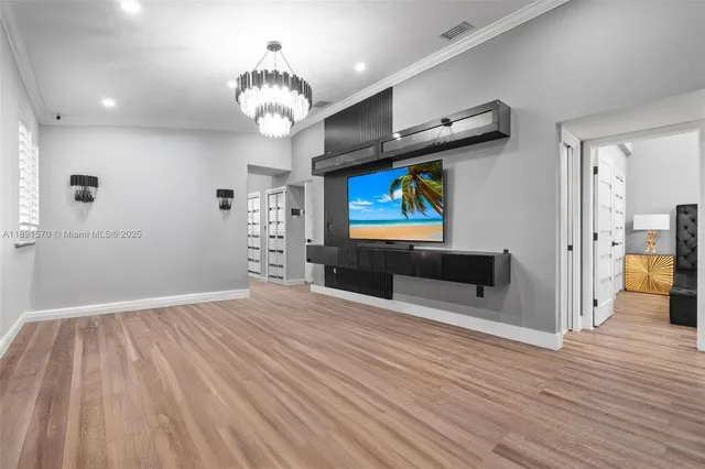a view of a livingroom with wooden floor and a ceiling fan