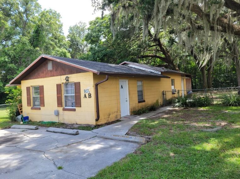 a front view of house with yard and trees in the background