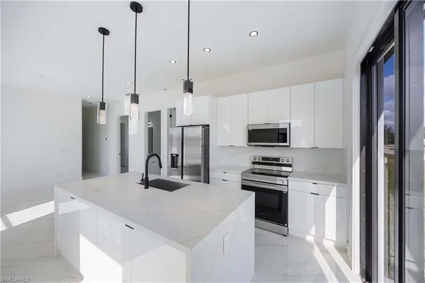 a kitchen with white cabinets and stainless steel appliances