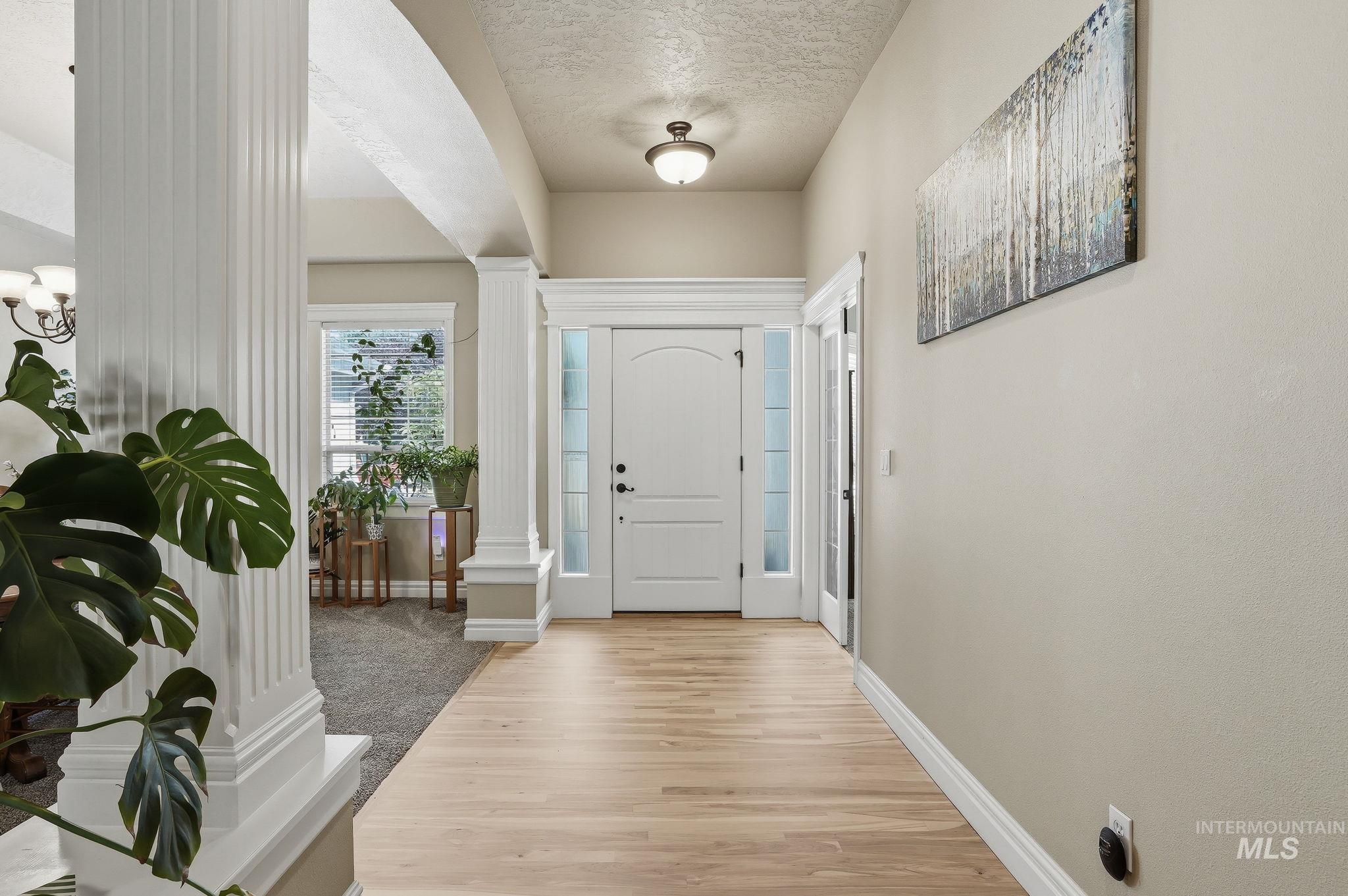 3969 North Hollymount Way Meridian, ID 83646 - Photo 4 of 47 Entryway featuring light wood-finish flooring, white paneled door with sidelights, and a ceiling-mounted light fixture