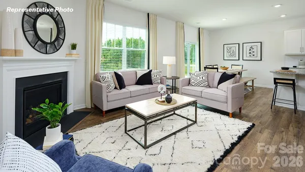 a living room with furniture a large window and a fireplace