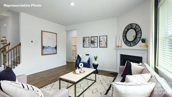 a living room with furniture a fireplace and a window