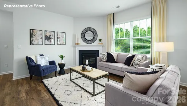 a living room with furniture a fireplace and a floor to ceiling window