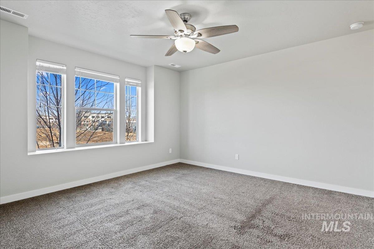 2471 East Goldstone Street Meridian, ID 83642 - Photo 17 of 27 Carpeted spare room featuring baseboards and a ceiling fan