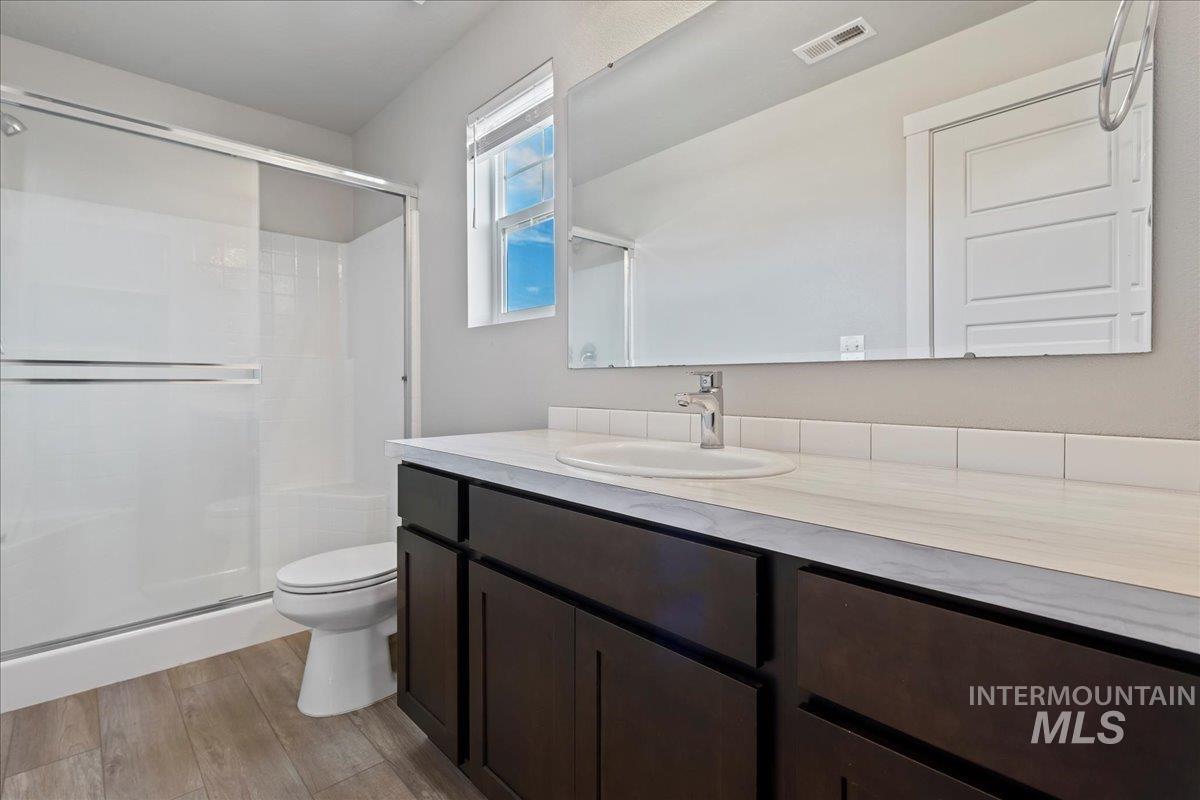 2471 East Goldstone Street Meridian, ID 83642 - Photo 19 of 27 Full bath with light wood-style floors, vanity, and a stall shower
