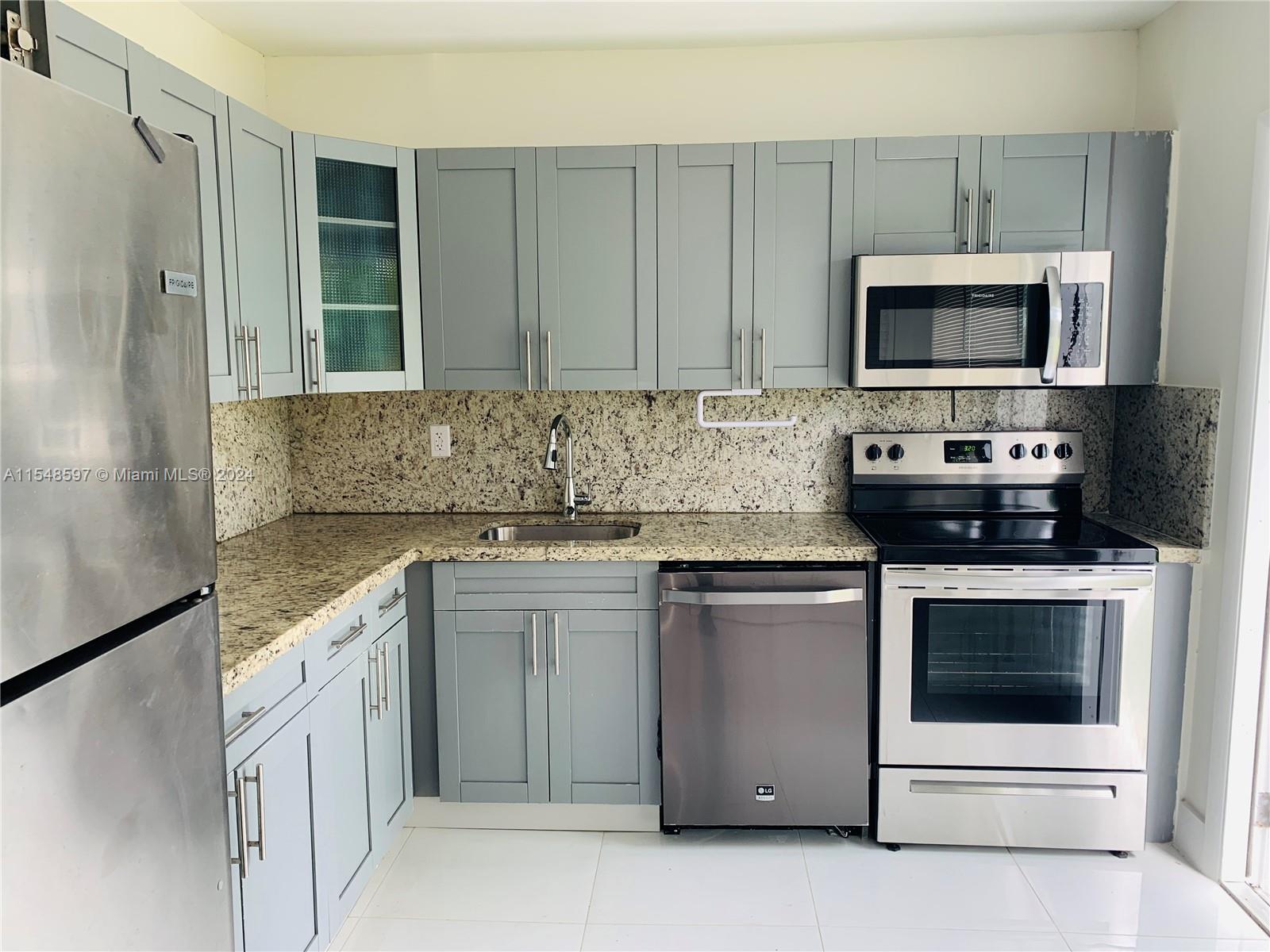 a kitchen with stainless steel appliances granite countertop a stove microwave and refrigerator