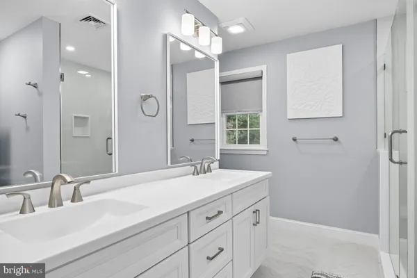 a bathroom with a sink vanity granite tub shower and a mirror