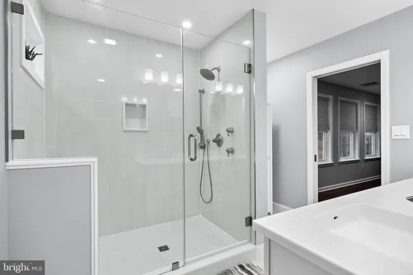 a bathroom with a shower a sink and a mirror