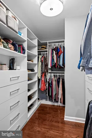a view of walk in closet with clothes and shoes
