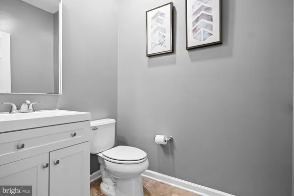 a bathroom with a toilet sink vanity and mirror
