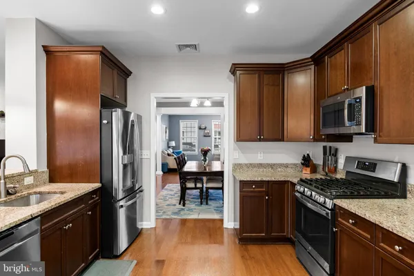 a kitchen with stainless steel appliances granite countertop a refrigerator stove and sink