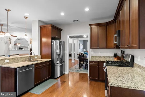 a kitchen with stainless steel appliances granite countertop a sink a stove and a refrigerator