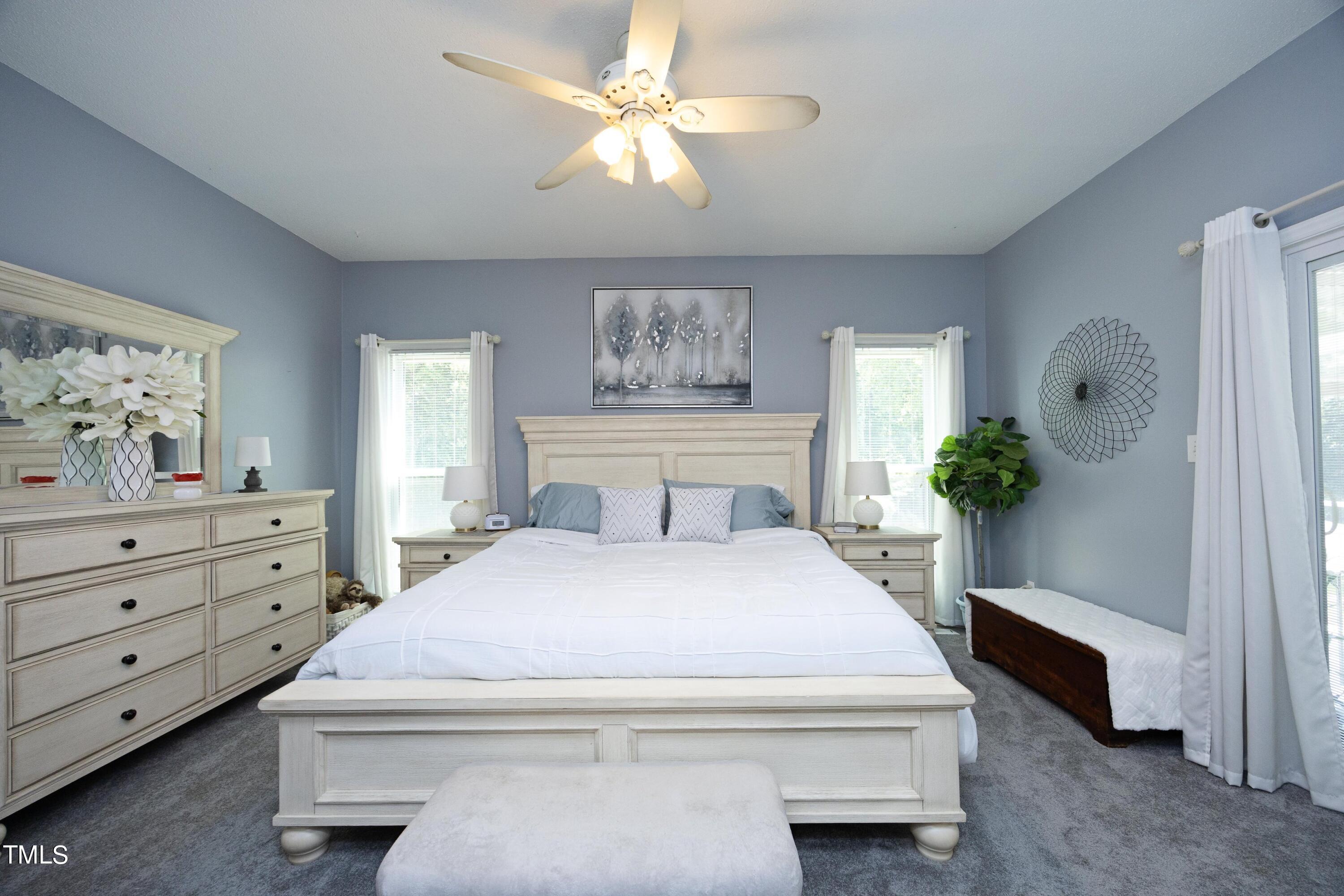 243 Bradley Drive Benson, NC 27504 - Photo 16 of 43 a bedroom with a bed and a chandelier