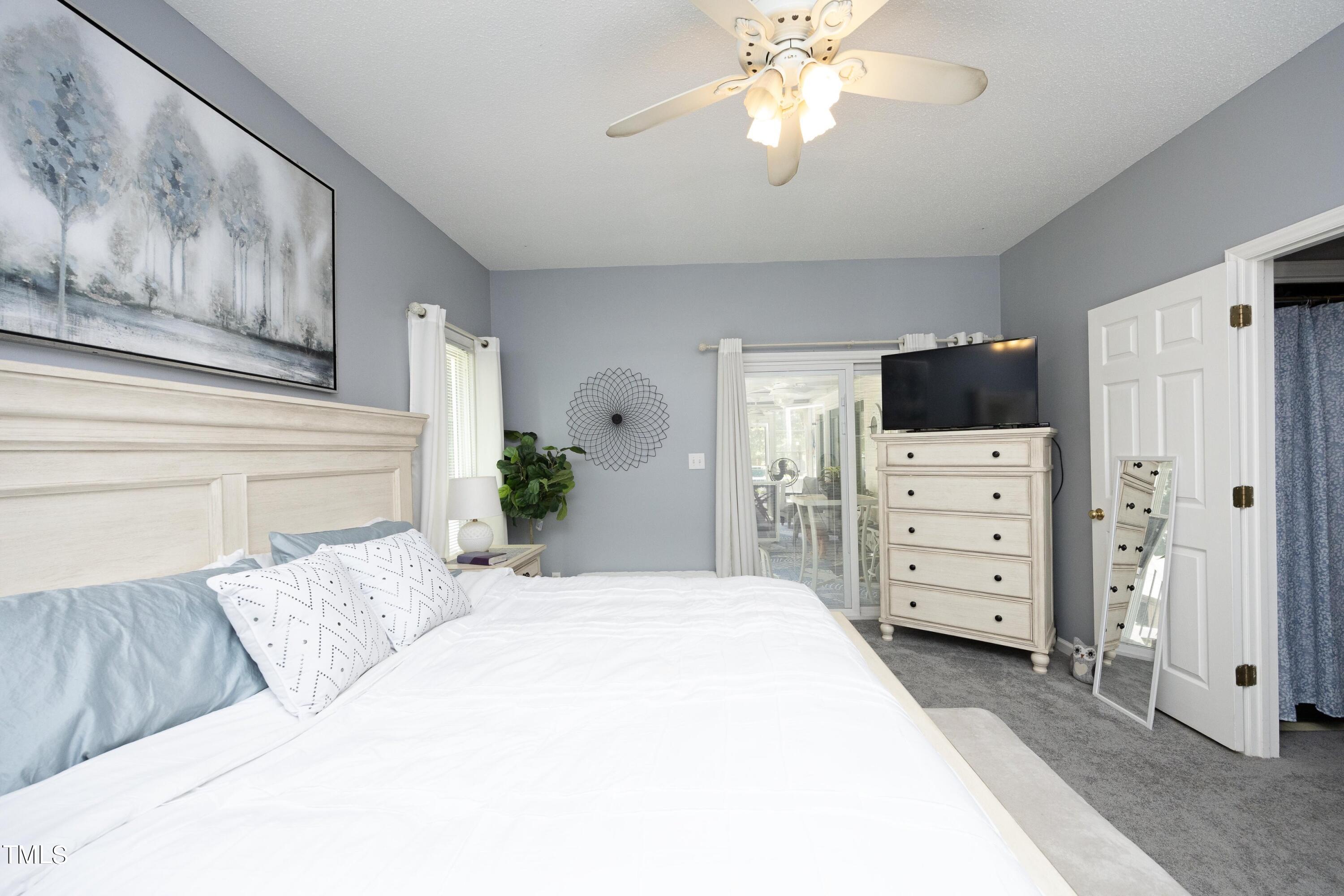 243 Bradley Drive Benson, NC 27504 - Photo 17 of 43 a bedroom with a bed a dresser and a chandelier