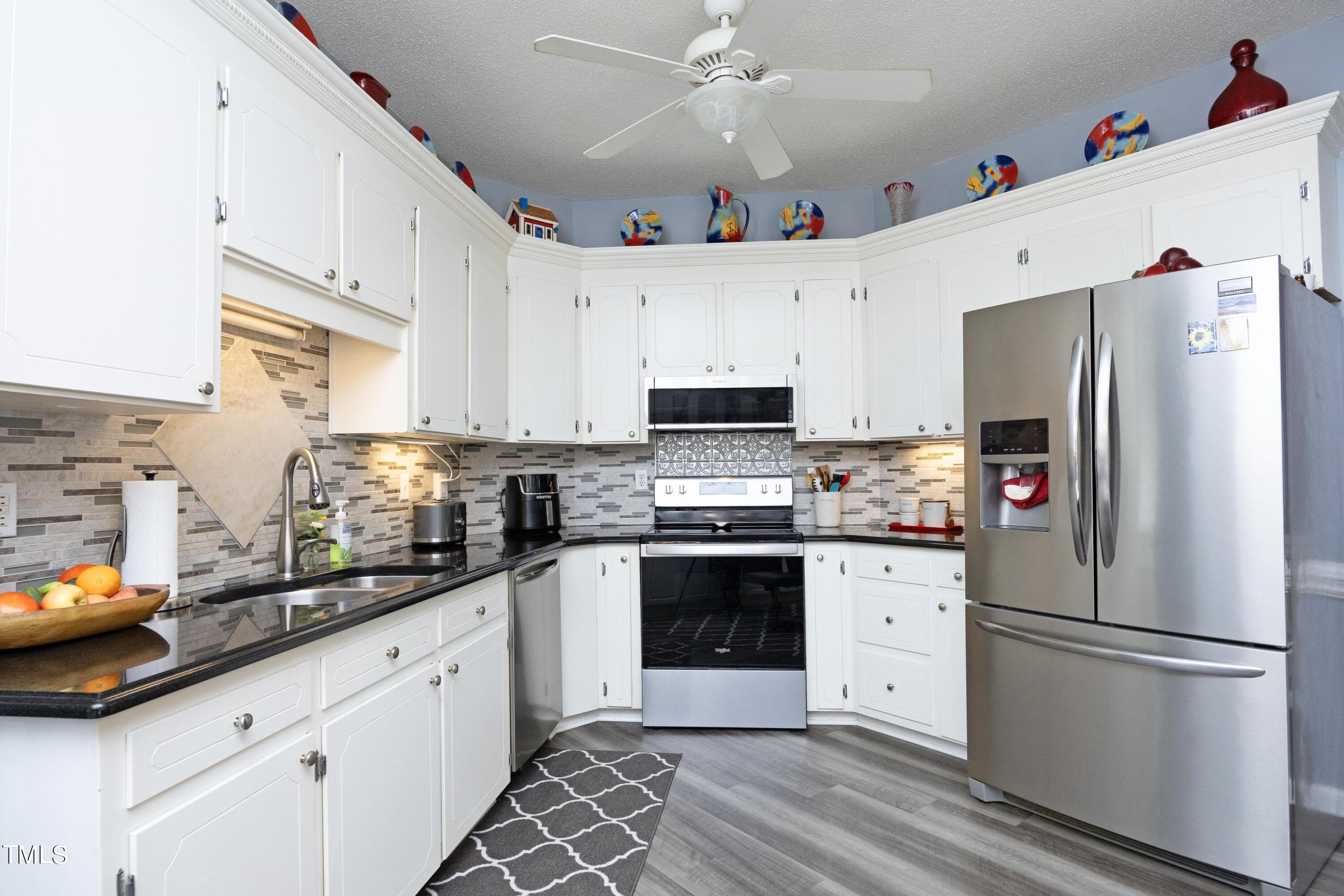 243 Bradley Drive Benson, NC 27504 - Photo 10 of 43 a kitchen with stainless steel appliances a refrigerator sink and cabinets
