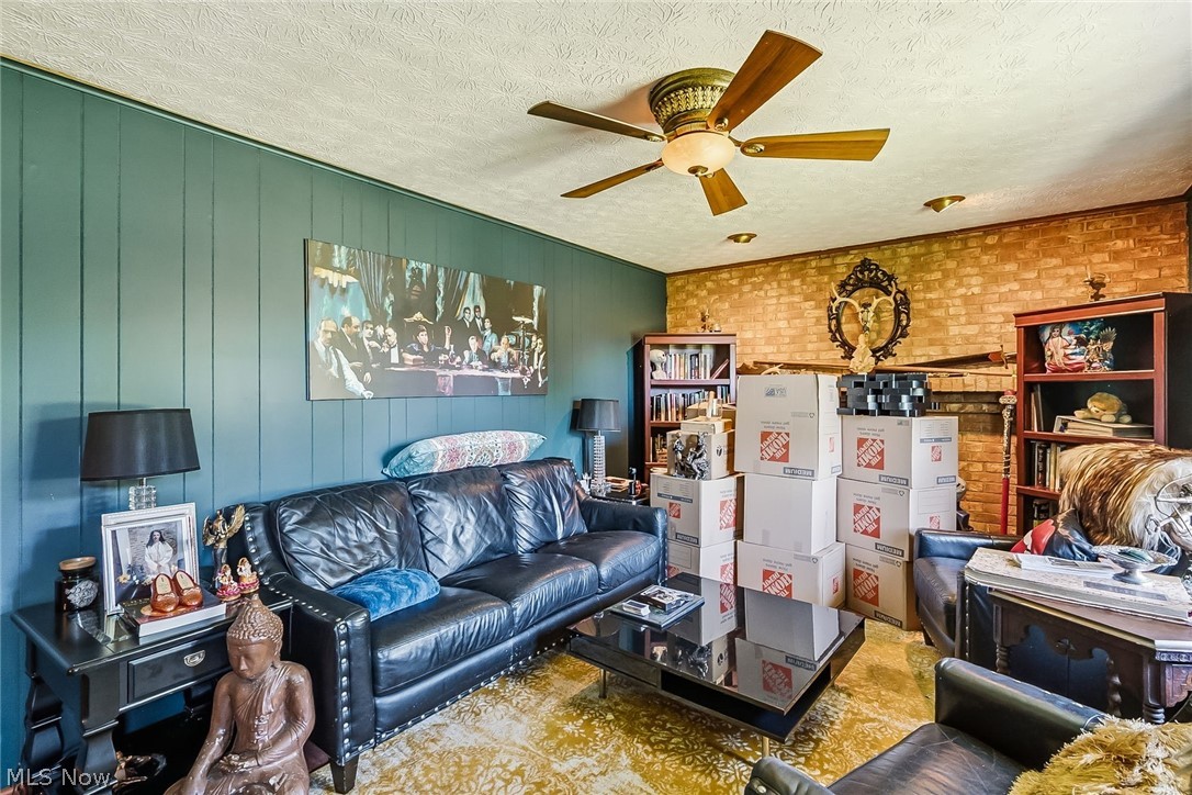 6890 Refugee Road Pickerington, OH 43147 - Photo 20 of 49 Spacious room featuring vertical paneling, exposed brick wall, and built-in shelving units