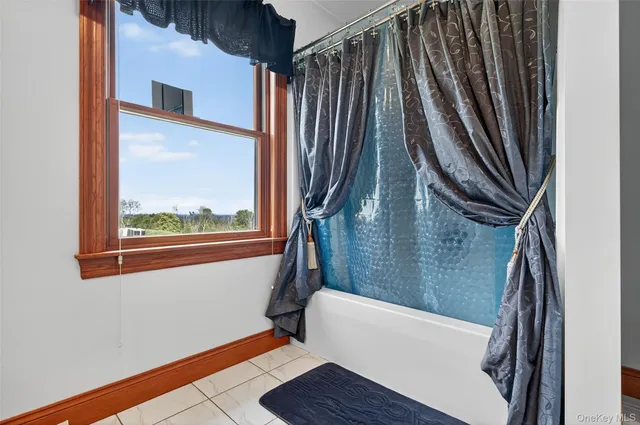 a spacious bedroom with a large bed a flat tv screen and dresser