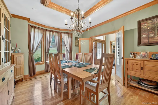 a bedroom with a bed a chair and potted plant with wooden floor