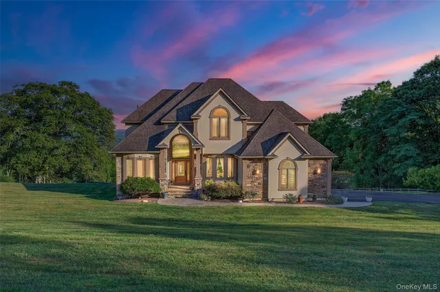 a view of a house with a yard and a large tree