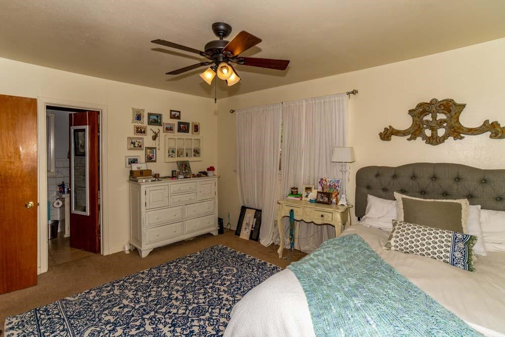 3706 41st Street Lubbock, TX 79413 - Photo 13 of 20 a bedroom with a bed and a chandelier