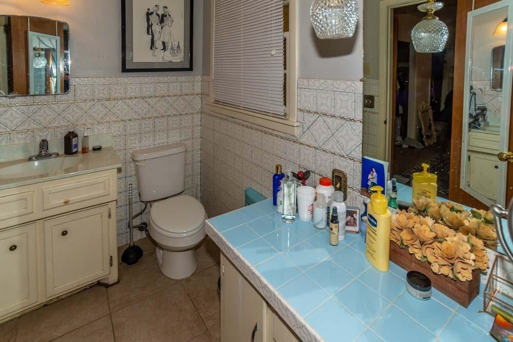 3706 41st Street Lubbock, TX 79413 - Photo 15 of 20 a bathroom with a toilet sink and mirror