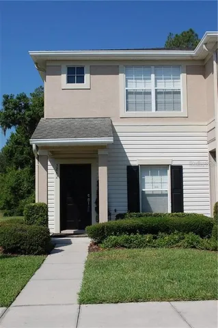 a view of a house with brick walls and a yard with plants