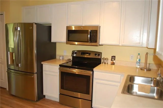 a kitchen with stainless steel appliances granite countertop a refrigerator stove and sink