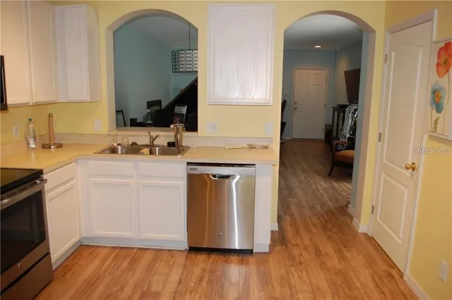 a kitchen with a sink cabinets and wooden floor