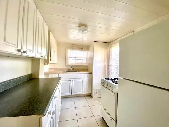 a kitchen with a sink a stove cabinets and a dining table