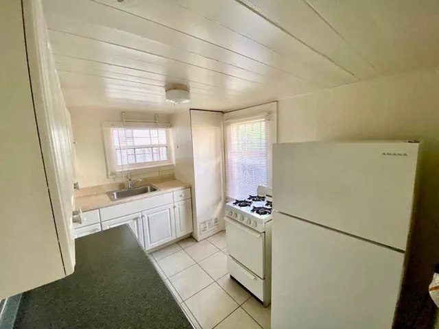 a room with white cabinets and white appliances