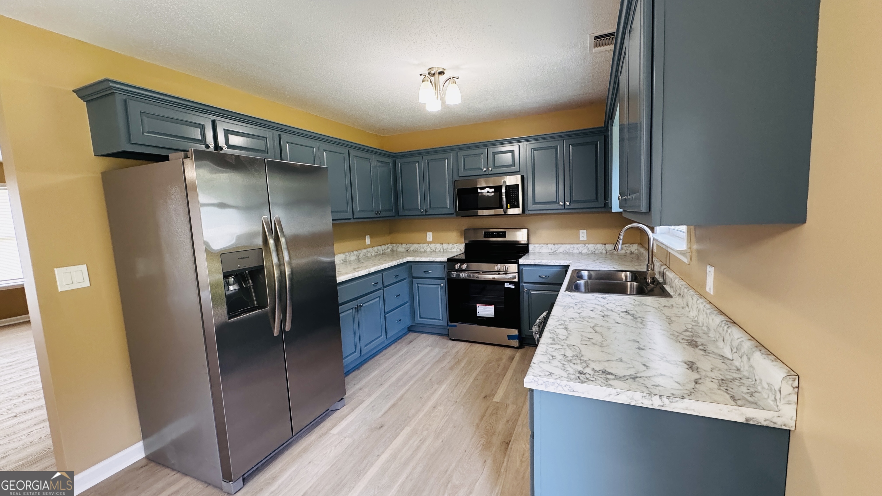 512 Antietum Road Collins, GA 30421 - Photo 3 of 16 a kitchen with stainless steel appliances granite countertop a refrigerator a sink a stove and a wooden cabinets