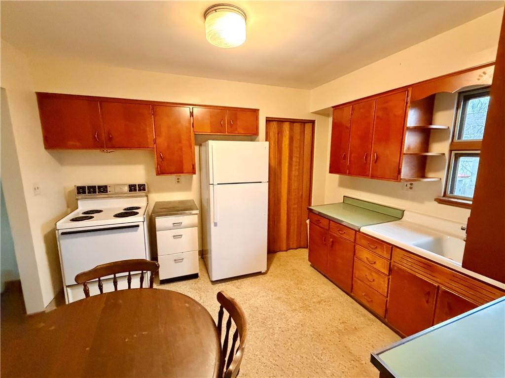 28 Union Street Uniontown, PA 15401 - Photo 5 of 9 a kitchen with a refrigerator a stove and a dining table