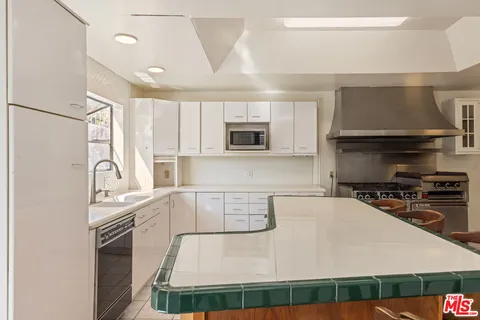 a kitchen with stainless steel appliances a stove sink and microwave
