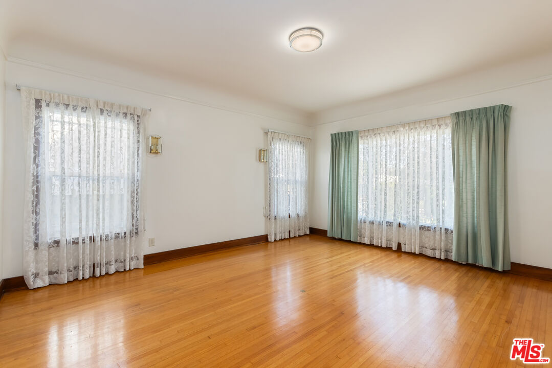 955 South Highland Avenue Los Angeles, CA 90036 - Photo 10 of 47 an empty room with wooden floor and windows