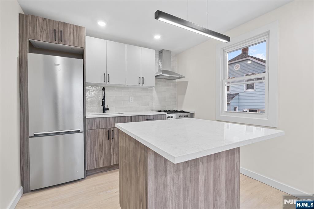 369 Hops Lane Secaucus, NJ 07094 - Photo 11 of 17 a kitchen with kitchen island a refrigerator a sink and cabinets