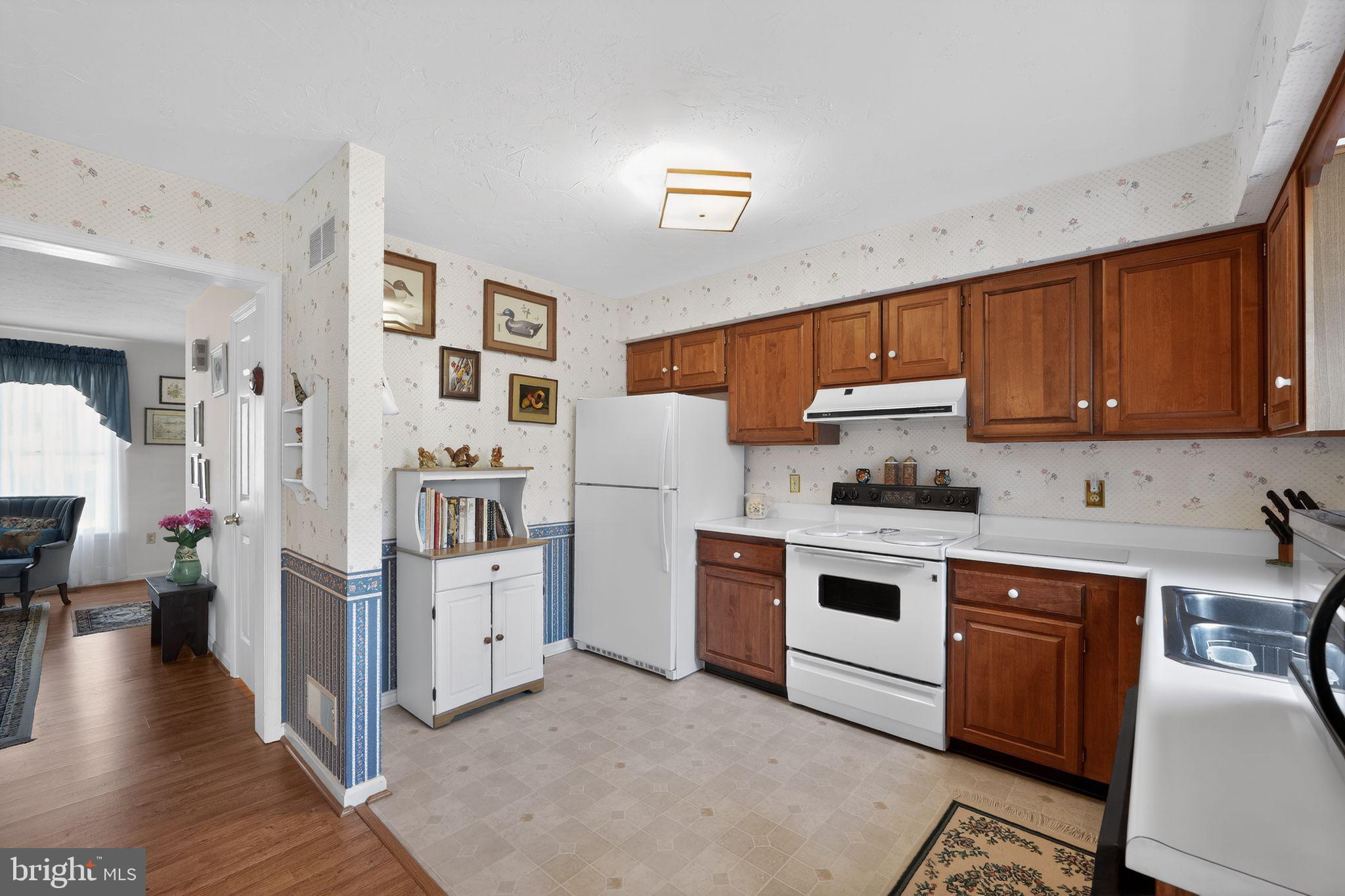 23 Crescent Lane Littlestown, PA 17340 - Photo 11 of 30 a kitchen with stainless steel appliances granite countertop a stove top oven a sink dishwasher and a refrigerator with wooden floor