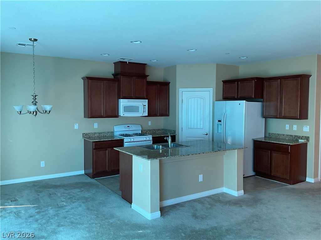 12 Jasmine Point Street Henderson, NV 89074 - Photo 3 of 15 A well-appointed kitchen features rich cabinetry, granite countertops, and modern appliances.