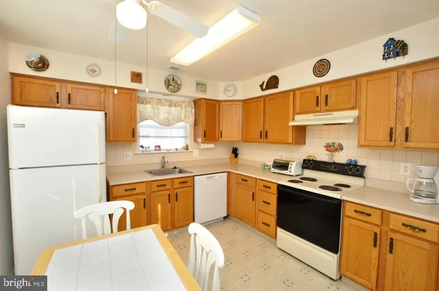 a kitchen with stainless steel appliances granite countertop a sink a stove a refrigerator and cabinets