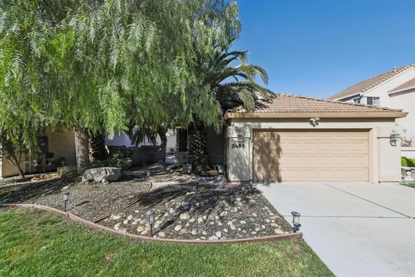 a view of a house with a small yard and potted plants
